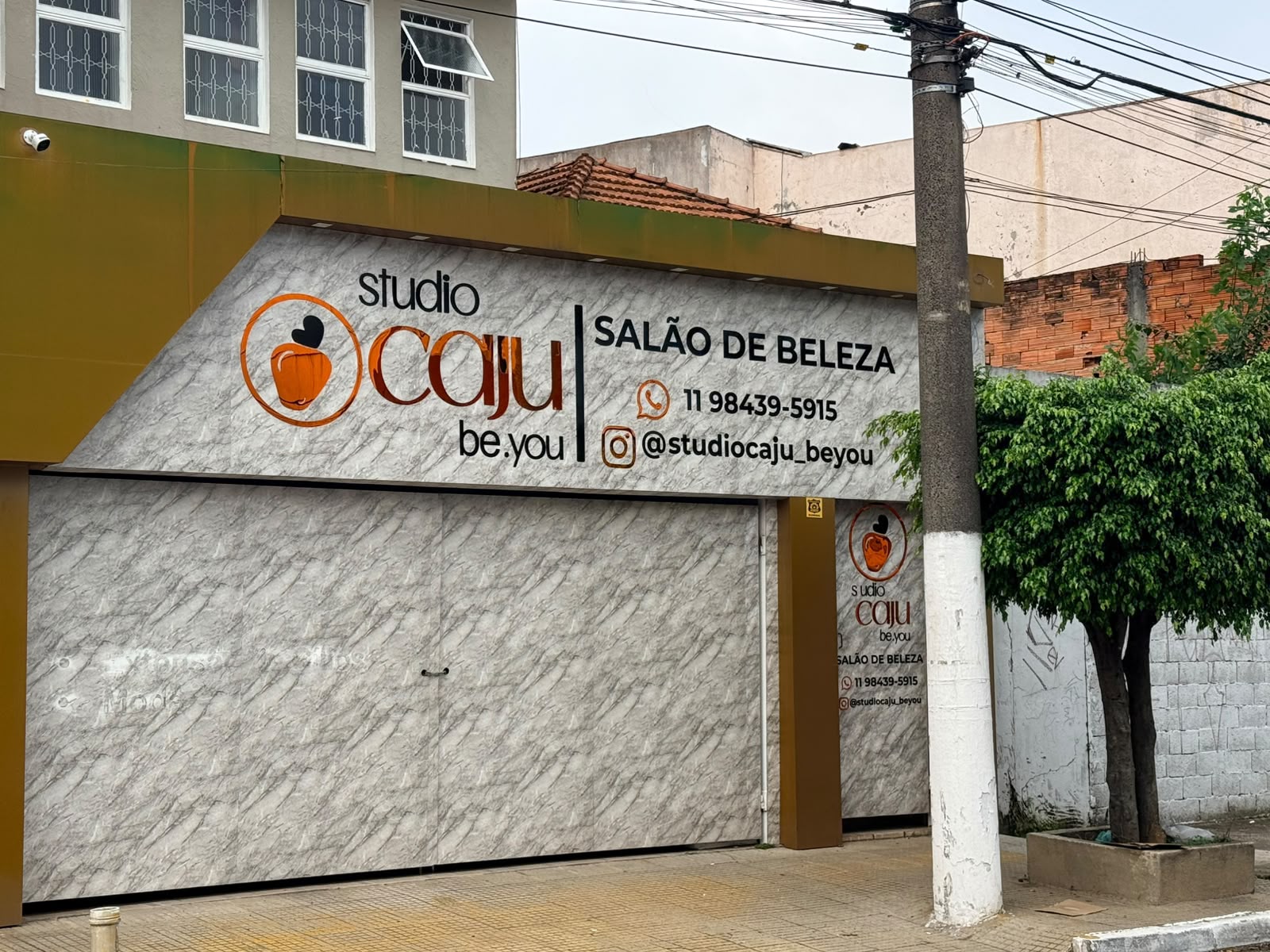 Fachada do Studio Caju durante o dia, com o logo e a identificação Salão de Beleza.